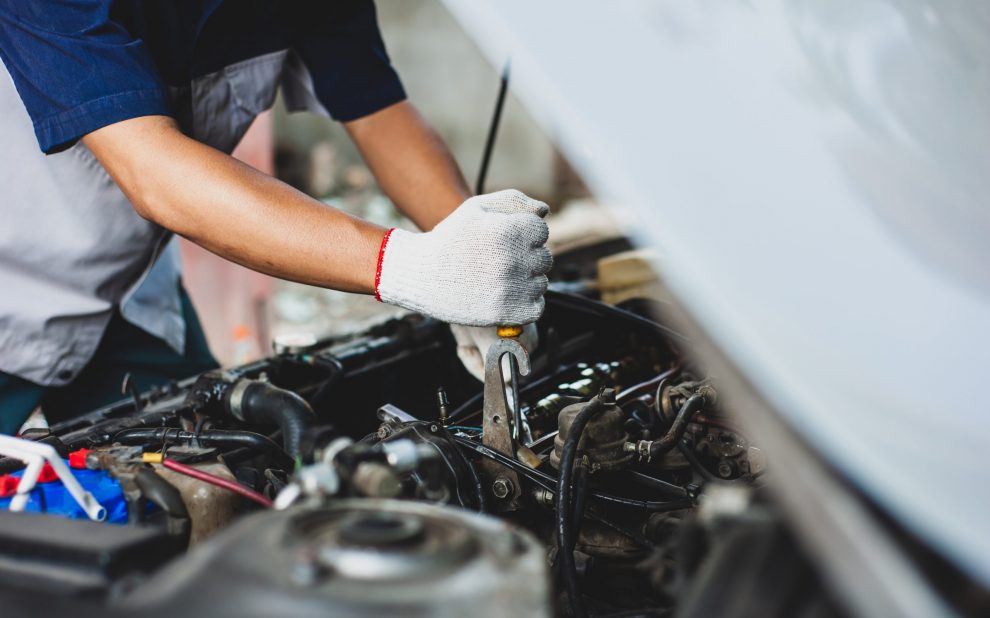 mechanic,uses,a,wrench,to,fix,the,car,engine.