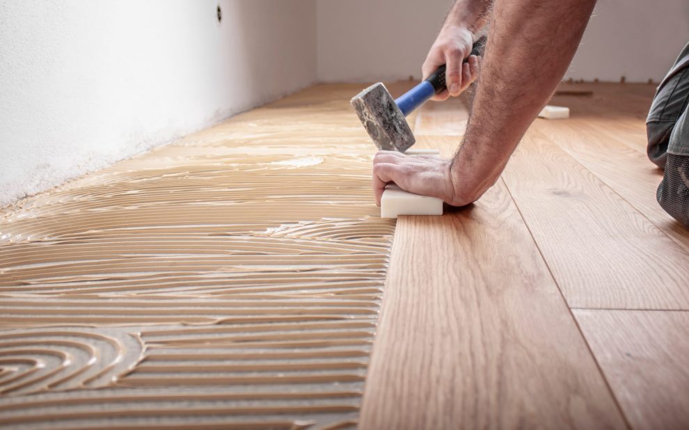 craftsman,lays,parquet,floor,and,spreads,the,glue,on,the